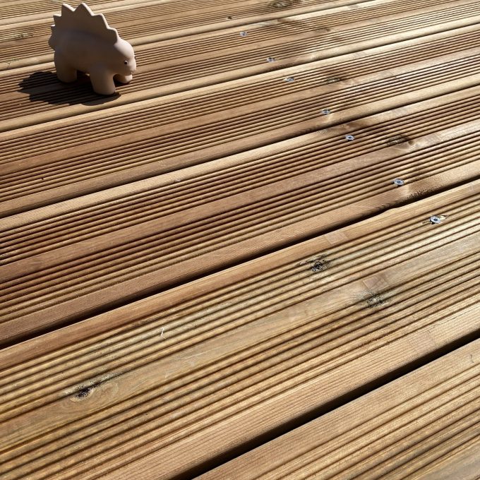 Lames de terrasse en pin sylvestre autoclave classe 3, jouet dinosaure sur platelage en bois naturel