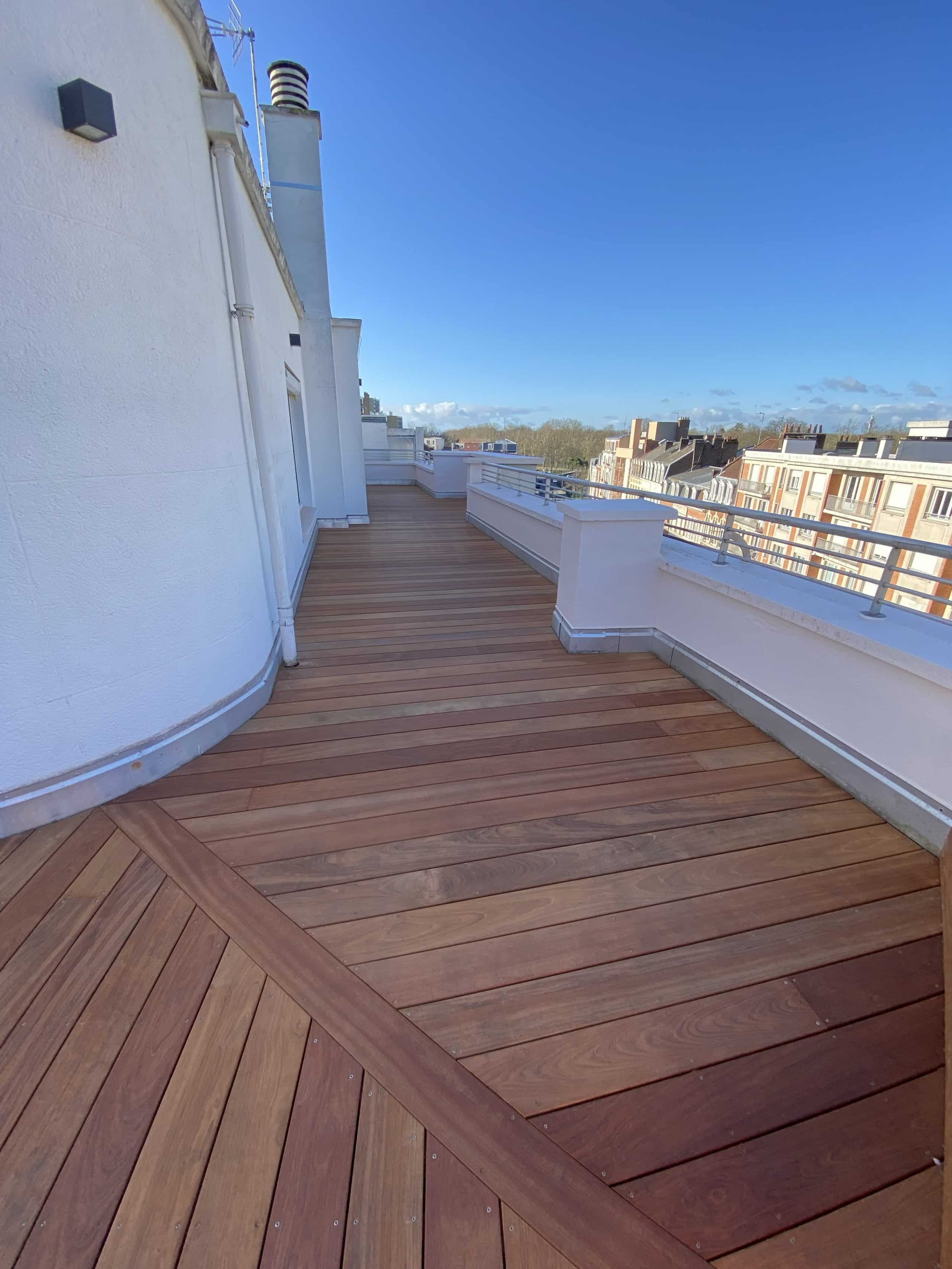 Terrasse en bois exotique sur un toit avec vue sur la ville